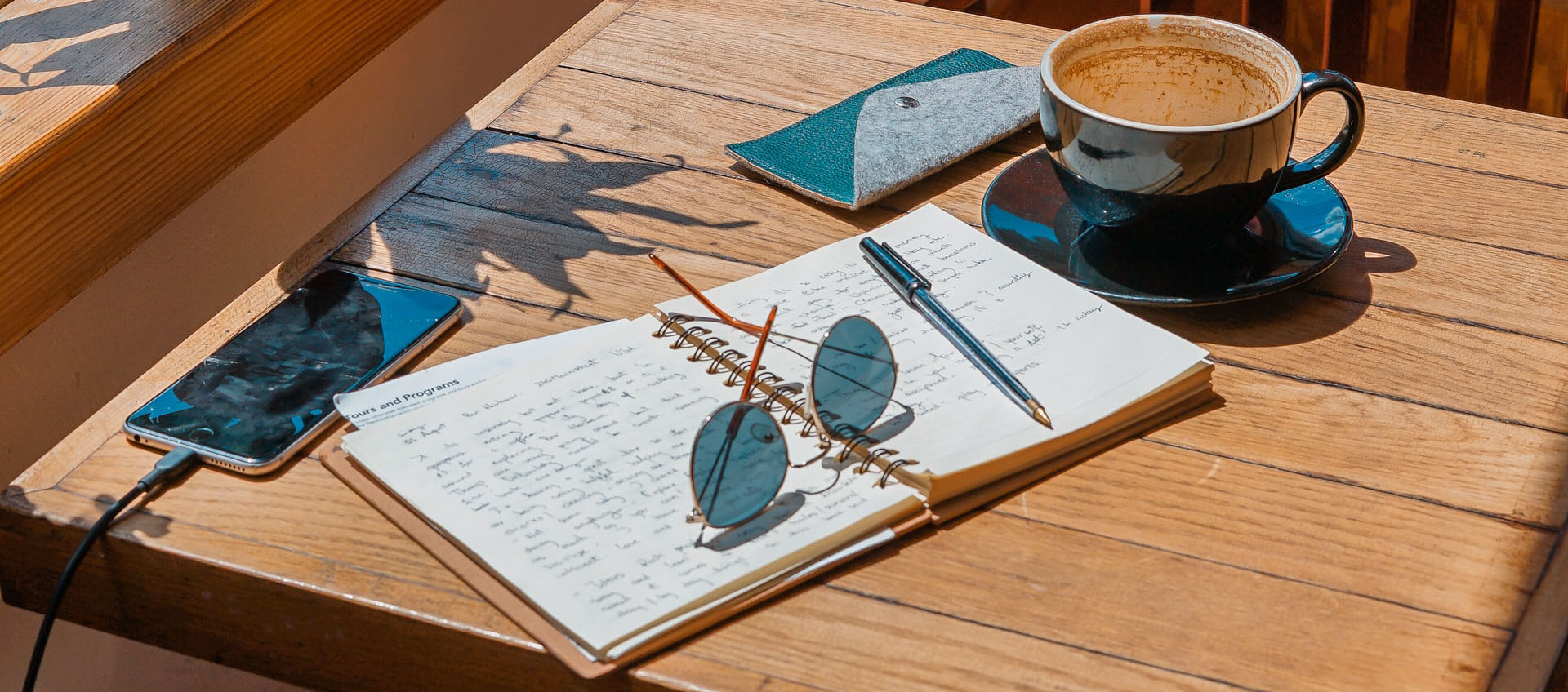 Mesa de cafetería con celular y cuaderno